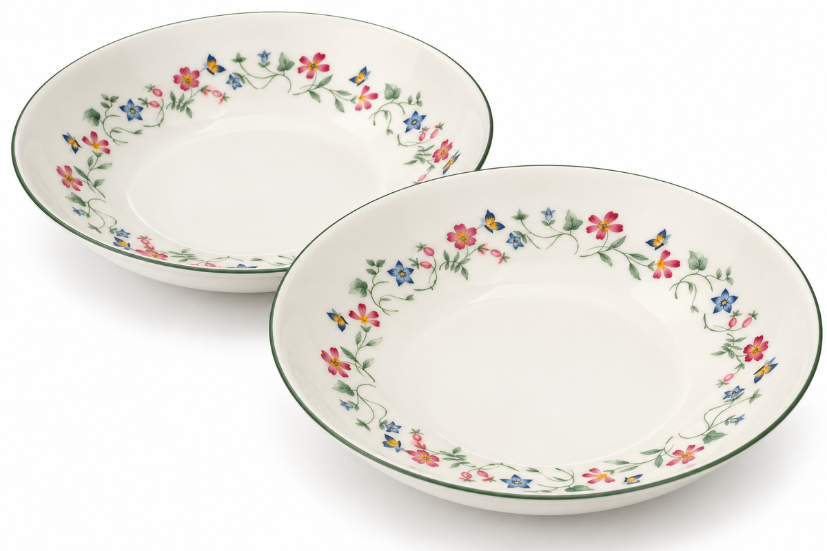 Two white ceramic bowls with a colorful floral border pattern and a thin green rim, shown on a clean white background.