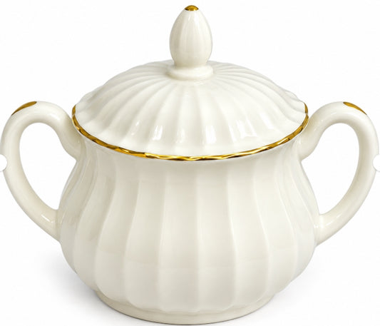 An off-white porcelain sugar bowl with a matching lid, featuring vertical fluted detailing, two side handles, and delicate gold trim accents.