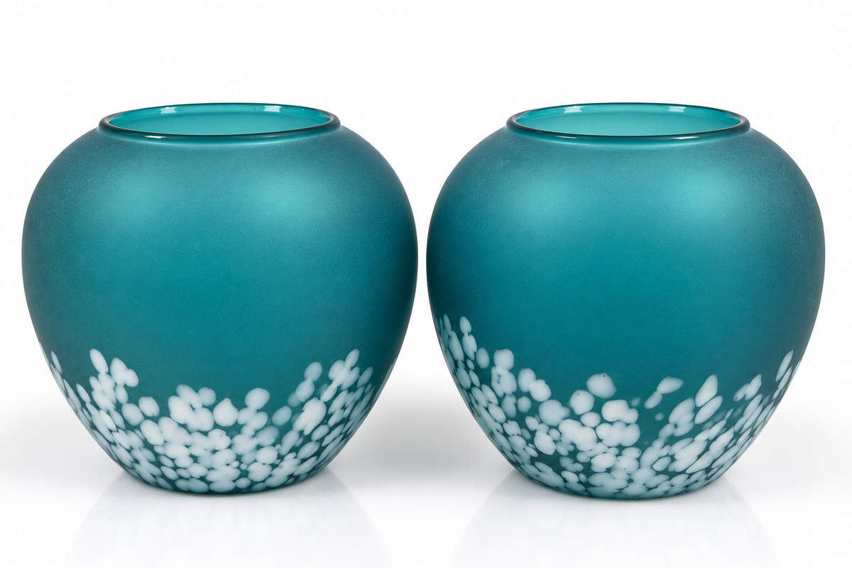 Two matching teal glass vases with a white floral pattern near the base, shown on a clean white background.