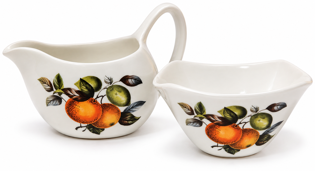 A white ceramic pitcher and matching bowl set decorated with a vintage-style fruit illustration featuring oranges, green apples, and leaves, set against a plain white background.